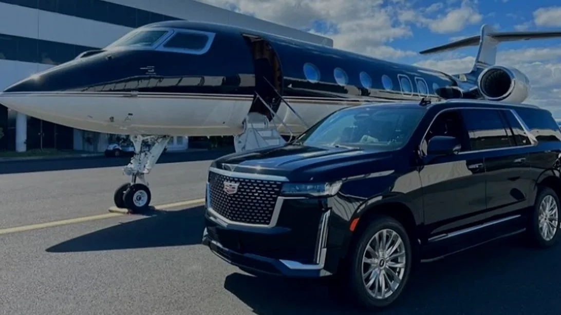Black Cadillac Escalade beside a private aircraft